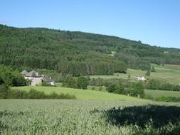 picturesque landscape of a house among green halls in France