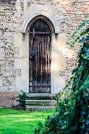 elongated wooden door in an ancient church