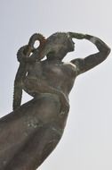 bronze female sculpture at sky