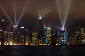 cityscape of laser show in Hong Kong's harbor at night