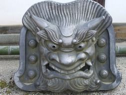 metal sculpture of the face at a buddhist temple