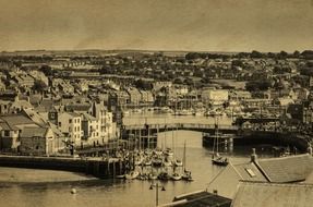 old black and white photo of a harbor with ships