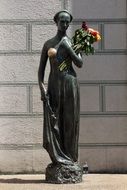 bronze statue of a woman with flowers