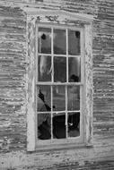 black and white photo of a broken window in an old house
