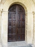 arched portal of cathedral with carved wooden door, spain, salamanca