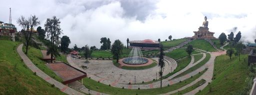 park with green fields and a fountain