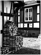 black and white photo of firewood near a house in Gengenbach