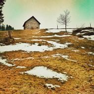 Landscape with the old farm house and snow in autumn