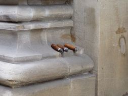 three cigars on a building column