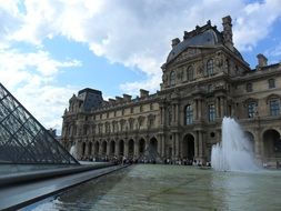 louvre, pyramid and fountain at palace, france, paris