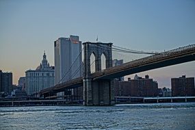 brooklyn bridge in front of city at dusk, usa, nyc