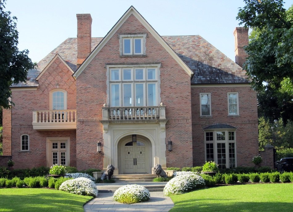 green lawn in front of a brick mansion