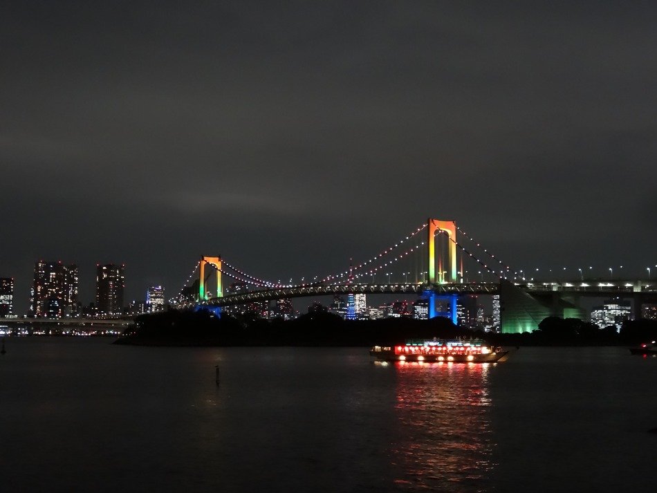 Raindow lighting bridge above the water near the buildimgs