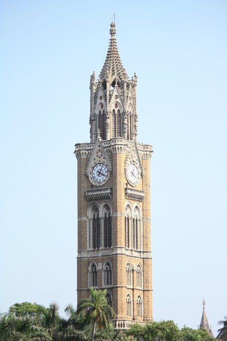 clock tower against the sky on a green hill