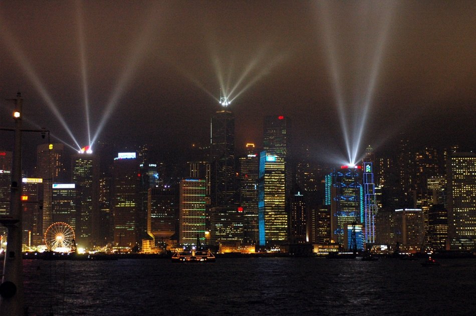 cityscape of laser show in Hong Kong's harbor at night
