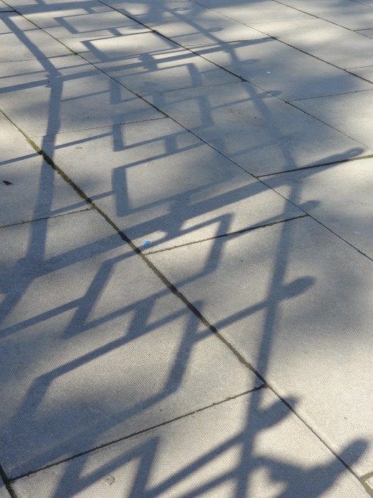 fence shadows on the paving