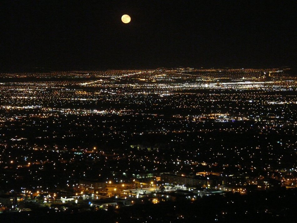 energy of the city at night and Moon in the sky