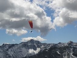glider in sky above mountains