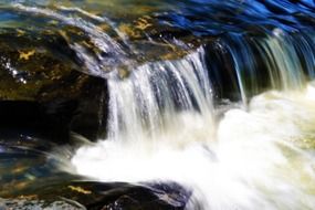 photo of a cascade of a mountain river in the wild