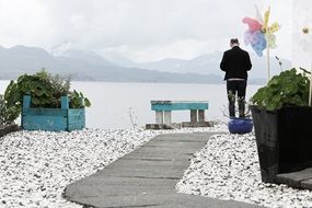 a man at the bench by the lake