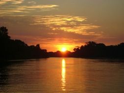 sunset over the lake among the forest