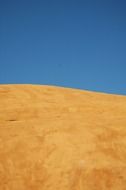 empty yellow sand and clear blue sky