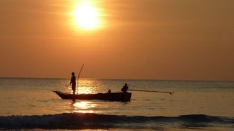 fishermen on a boat at dusk