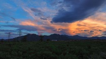 panoramic landscape of mountains and high-voltage towers at sunset