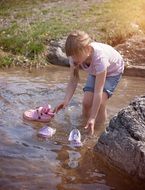 girl bathing her shoes in the brook