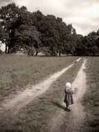 old photo of a child walking along the trail