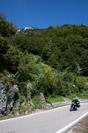 A motorcycle rides through a mountain pass