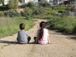 Girl and boy are sitting on the ground
