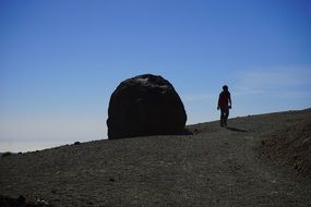 man walking near ball stone in the mountains in tenerife