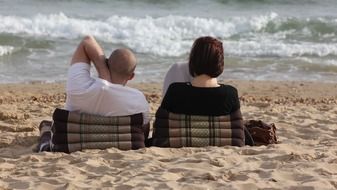 couple is resting by the ocean