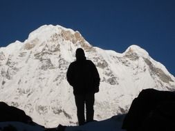 silhouette of a wanderer on the background of the snow mountain of Annapurna in the Himalayas