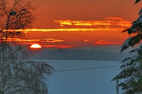 romantic sunset over a snowy landscape in the orange twilight