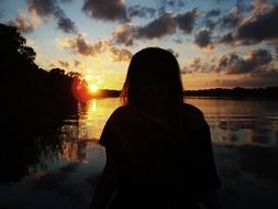 shadow of a girl at sunset by the water