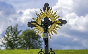 black cross with a figure of Jesus in the cemetery