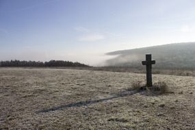 cross on a hill in frosty weather