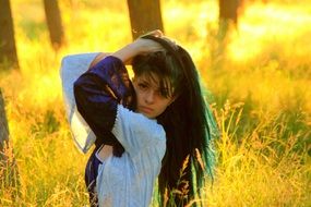 girl with long black hair on a background of golden grass