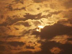 red sun behind the clouds at dusk