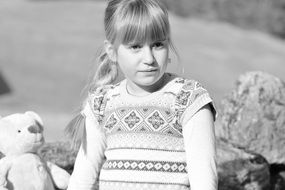 black and white photo of a girl with a teddy bear
