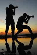 two photographers take pictures of the beach