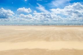 landscape of clear sky with white clouds over a sandy beach