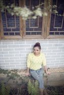 young woman leaning on old mansion walls