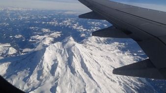 view of snow mountain from an airplane window