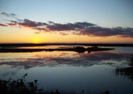 sunset with sky reflection in still water, usa, florida, merritt island