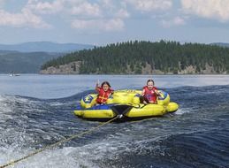 children ride on the lake