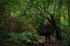 girl among thick green trees