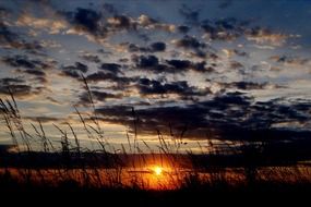 sunset in the clouds over the field